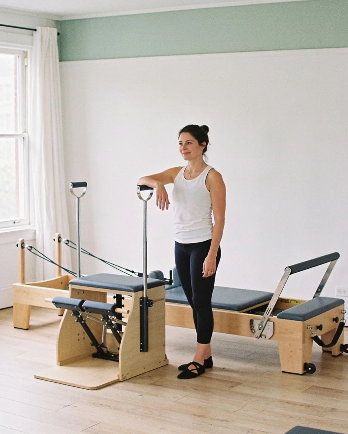 Chloé Martin, fondatrice du studio, la main posée sur un Reformer