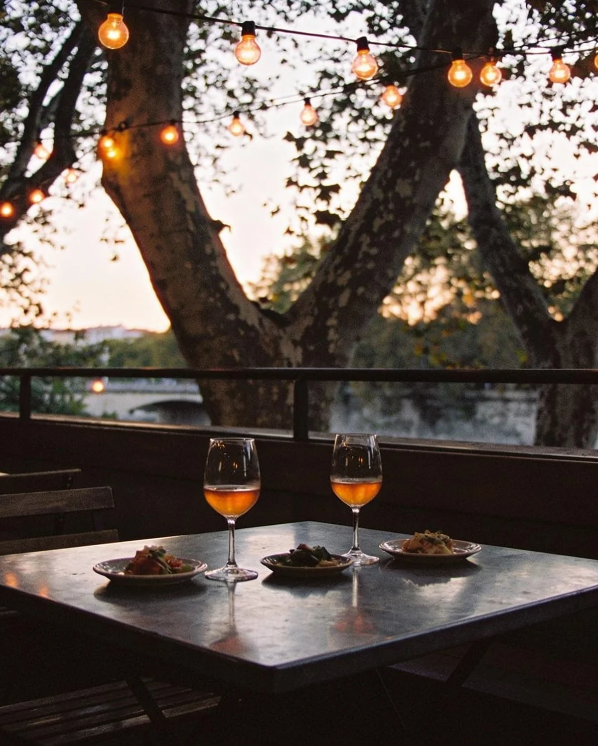 La terrasse un soir de septembre, verres de vin et petites assiettes sous les platanes